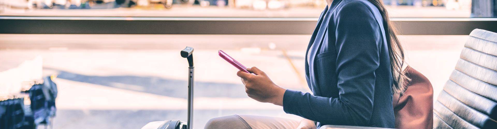 Woman checking phone while waiting for departure flight