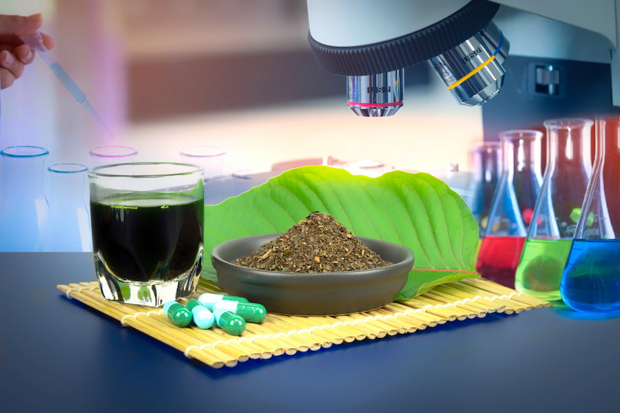 Herbal Supplement liquid, powder, and capsules with a microscope