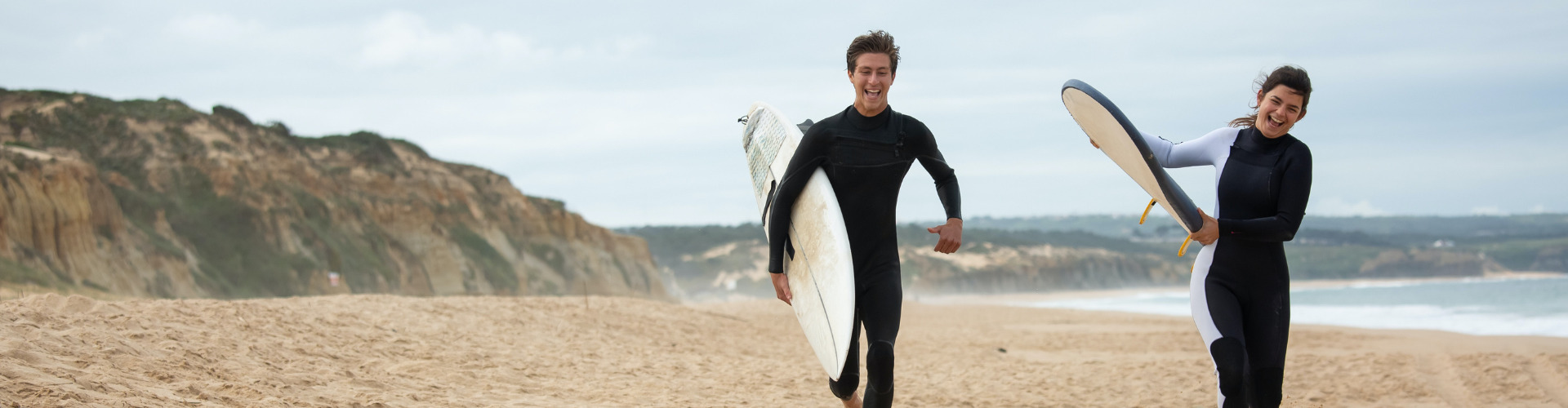 a couple surfing on the beach.