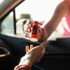 Woman handing Boost bottle through car window